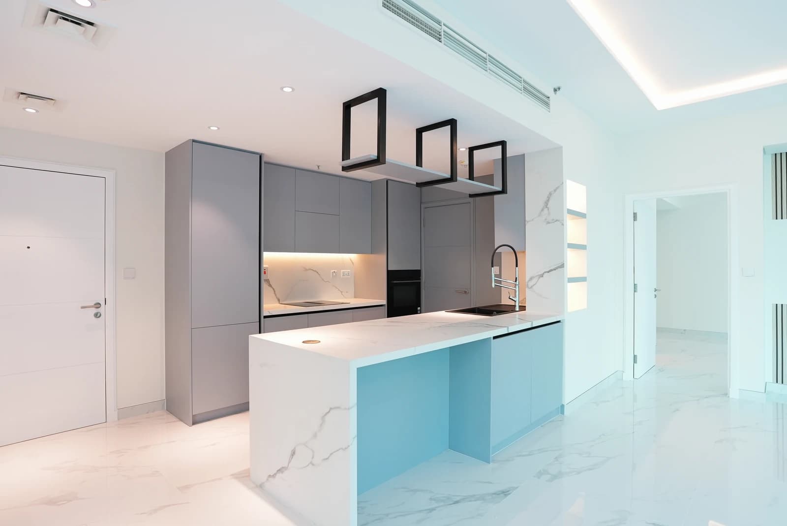 Modern grey apartment kitchen with geometric lighting in Dubai Marina