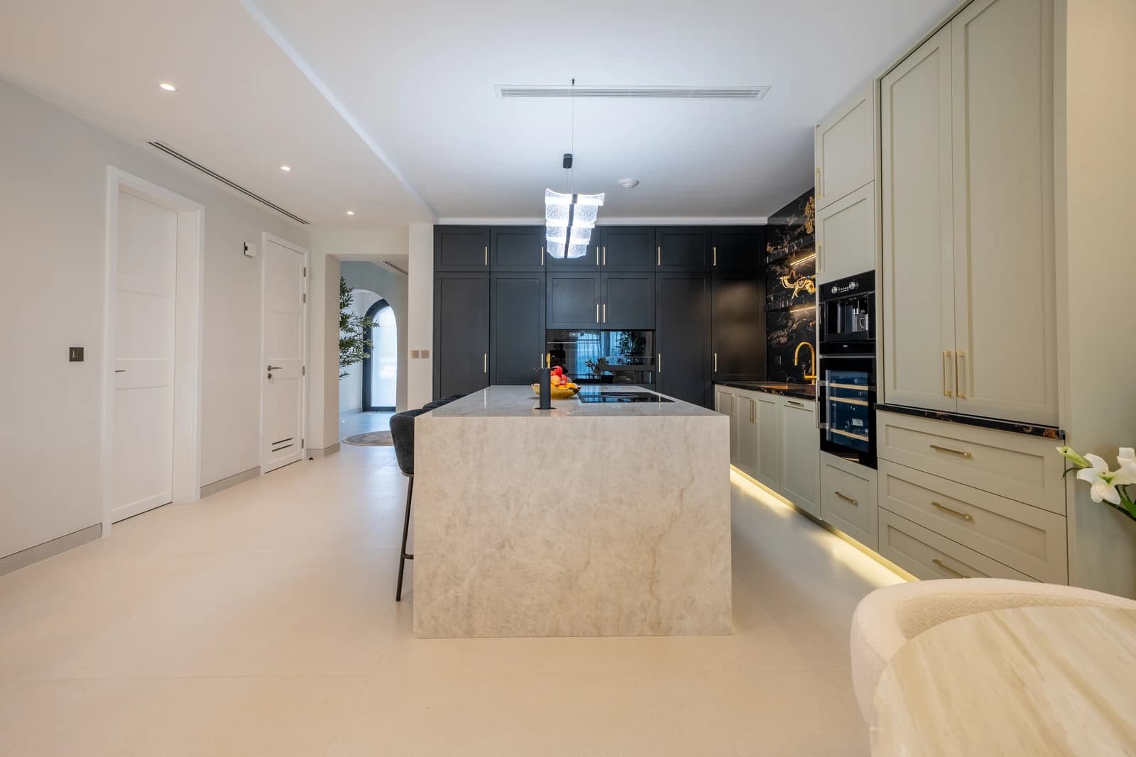 Vigilant custom kitchen with marble waterfall island in a Jumeirah Golf Estates villa
