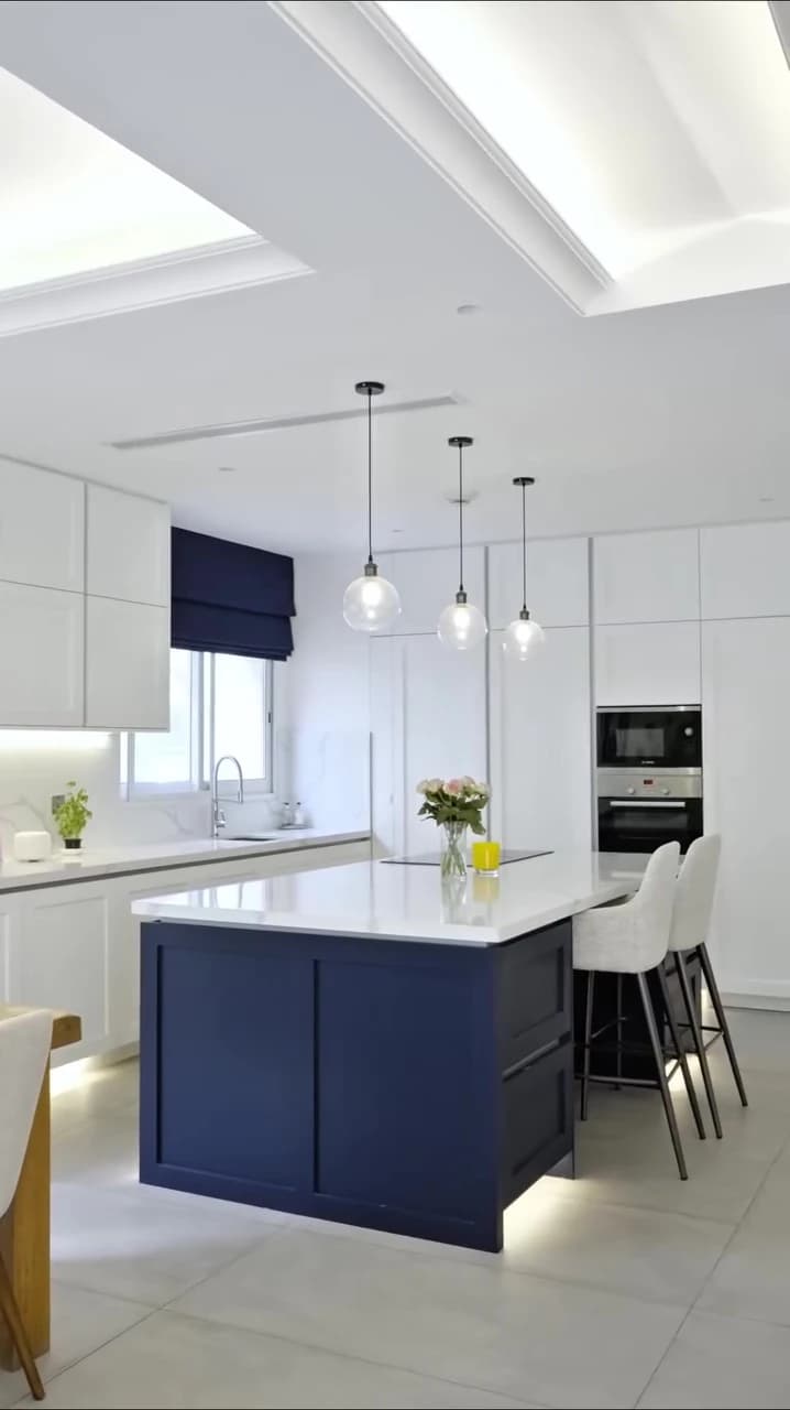 White kitchen with navy island and pendant lighting in Jumeirah Golf Estates