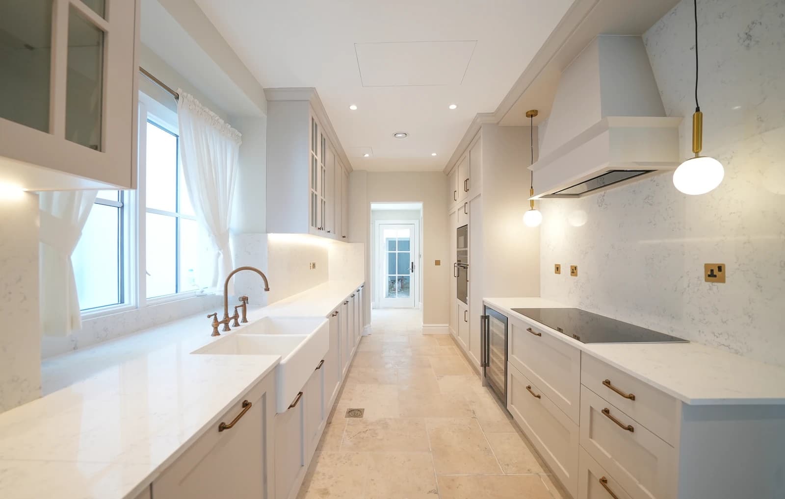 Classic white galley kitchen with brass fixtures in Whispering Pines